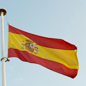 the spanish flag is flying high in the sky